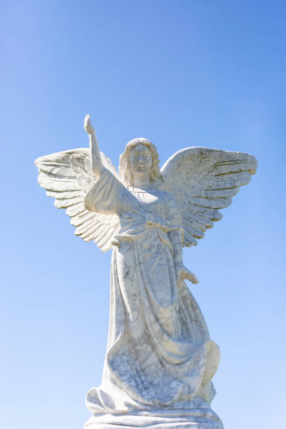istock Angel, old statue of angle, front view, light blue sky background with copy space 1282731393