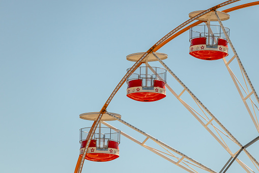 3 chairs of the ferris wheel carousel, with blue sky in the background, at the fair Magic Cube in Viseu, year 2020, Portugal