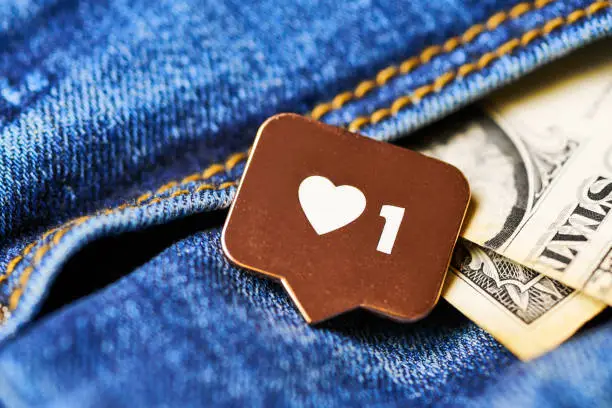 Photo of Like heart symbol and dollar in jeans pocket