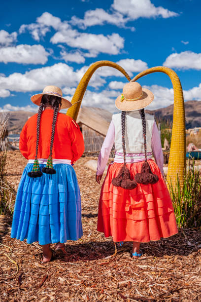 dos mujeres peruanas felices en la isla flotante de uros, lago tititcaca - trajes tipicos del peru fotografías e imágenes de stock