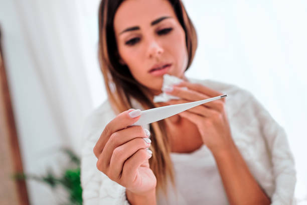 istock Young woman sick in bed with temperature 1282734577