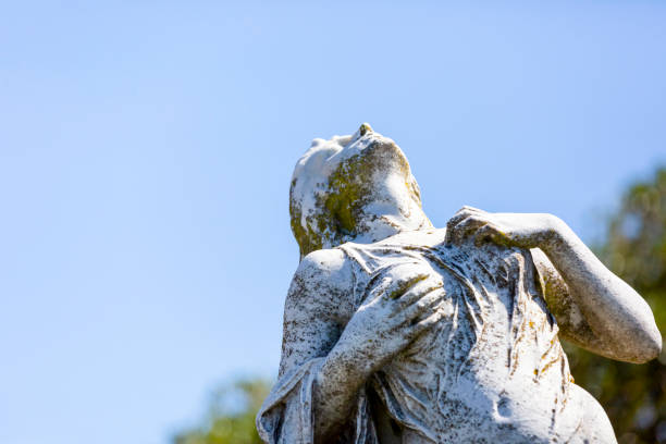 Old statue of grieving young woman, background with copy space