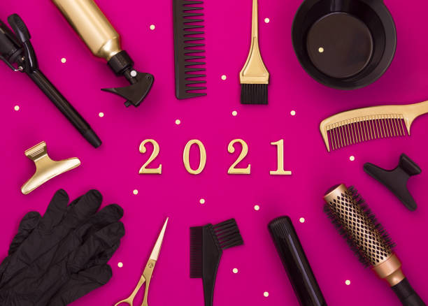 istock New year's background with hairdressing tools and numbers 2021. Scissors, combs, clips and Curling irons. Gold and black hair salon accessories on bright pink. 1282737721