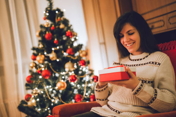 istock Woman opening wrapped Christmas gift 1282737729