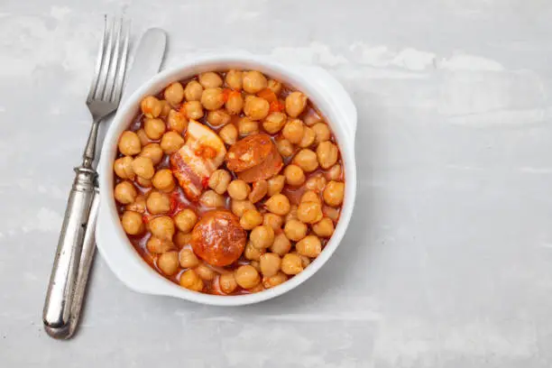 Photo of chick-pea with smoked sausage in white bowl