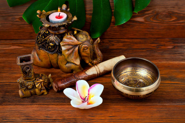 코끼리와 촛불이 있는 티베트 노래 그릇 - om sound 뉴스 사진 이미지