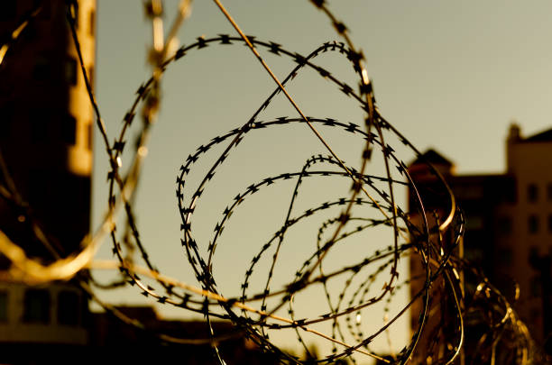 istock A barbed wire in prison. Barbed wire against the sky 1282740209