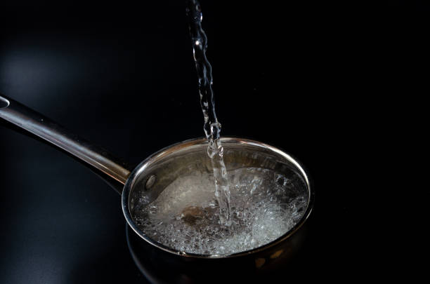 istock Water is poured into the pan on a black background 1282740233