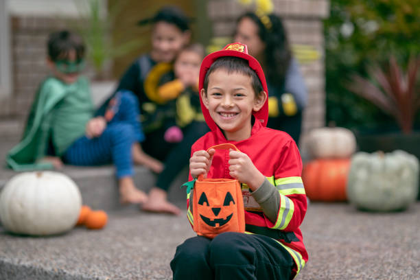 istock Elementary age boy in firefighter costume holding bag of Halloween candy 1282744556