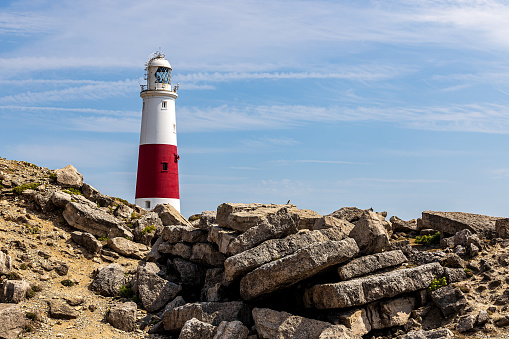 A rocky out crop with Portland lighthouse in the background on a bright summers day.