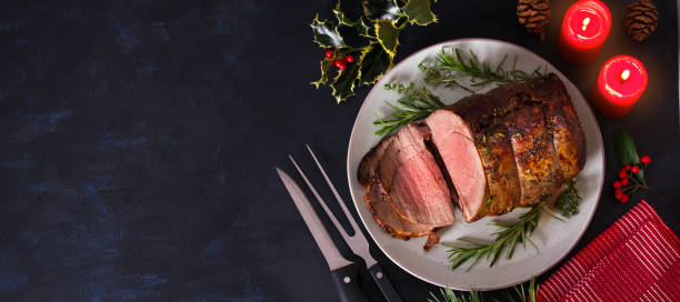 Roasted beef. Christmas decorations. New Year dinner table Roasted beef. Christmas decorations. New Year dinner table. View from above, top studio shot, copy space roast beef photos stock pictures, royalty-free photos & images