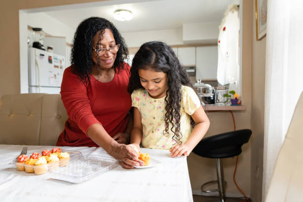 istock Black aunt and niece arranging cupcakes at home 1282750245