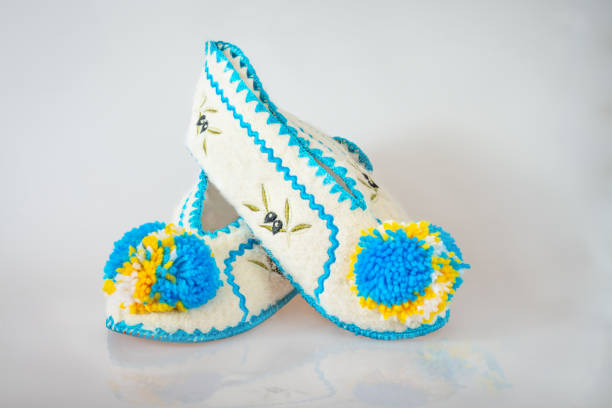Pair of Greek slippers with pumpons on gray background