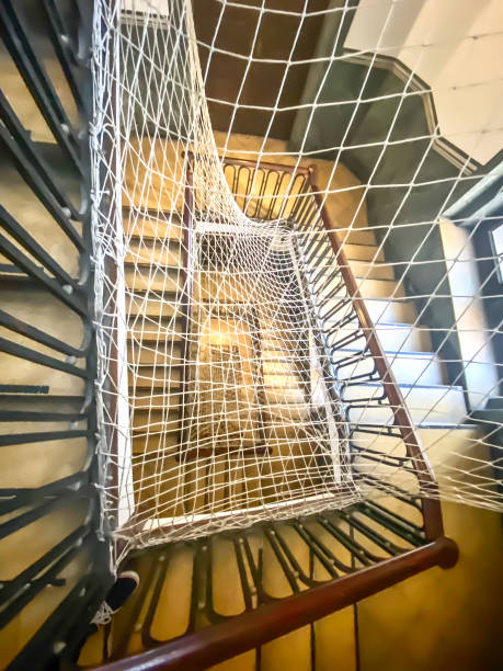 Safety net in the hole of the interior staircase in an old building Safety net in a residential building in Spain, to stop danger from falling down the staircase safety net stock pictures, royalty-free photos & images