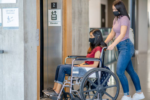 istock Female university student in a wheelchair using the elevator 1282751564