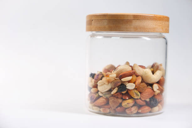a jar of mixed nut isolated on white background .