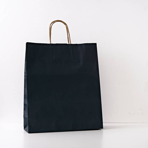 istock Gift black paper bag on a white background. Copy space, flat lay, mock up, top view. 1282756615