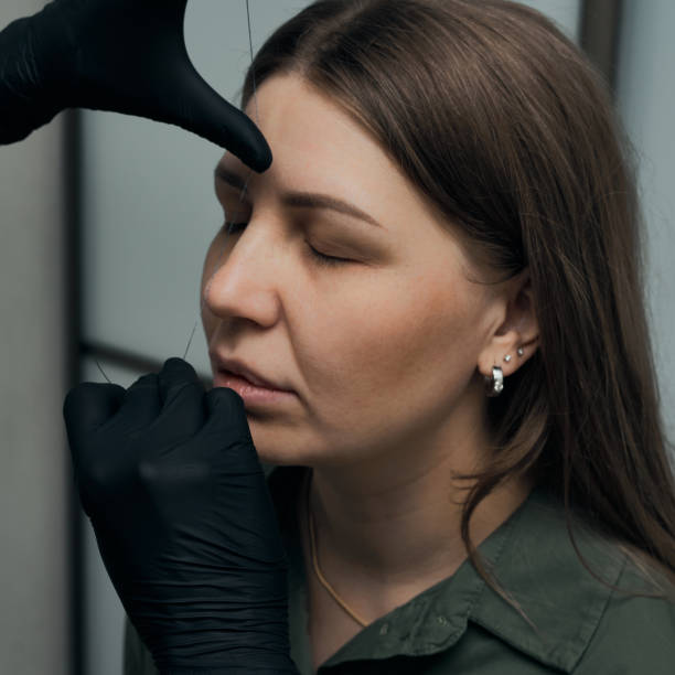 istock Permanent eyebrow makeup procedure. Eyebrow tattooing, process. The use of tools by a master for permanent eyebrow makeup. 1282756765