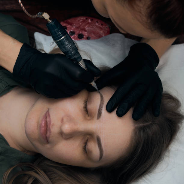 istock Permanent eyebrow makeup procedure. Eyebrow tattooing, process. The use of tools by a master for permanent eyebrow makeup. 1282756770