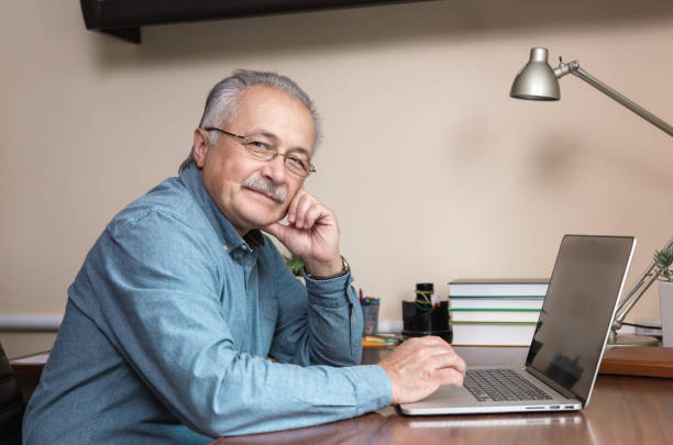 istock Senior businessman work at home. An elderly man in glasses is working remotely using a laptop. Remote work during coronovirus concept 1282758502