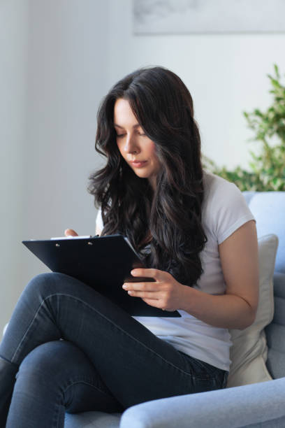 istock Brunette youmg woman fill in information in questionnaire making application for hire on vacancy 1282758663