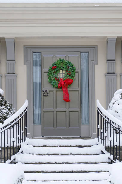장식계절 또는 크리스마스 화환이있는 현관 문, 눈 덮인 계단 - wreath christmas door snow 뉴스 사진 이미지