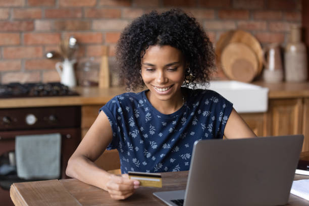 istock Smiling African American woman paying online on computer 1282763812
