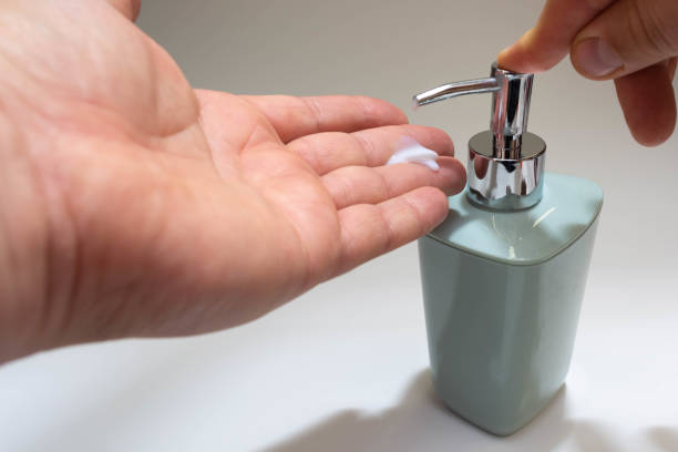 istock Close-up of a man's hand using a portable antibacterial hand sanitizer. 1282765415
