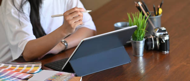 istock Cropped shot of attractive female designer using tablet for work while sitting in office. 1282775075
