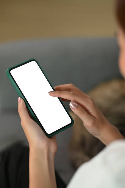 istock A young female using smartphone device typing an sms message at social network while sitting on sofa at home. 1282775086