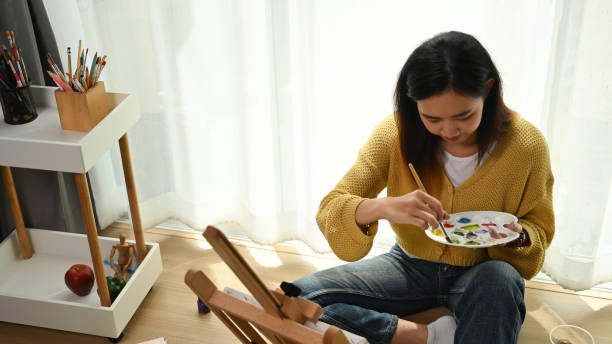 istock A female Artist working on painting in her bright daylight studio. 1282775619