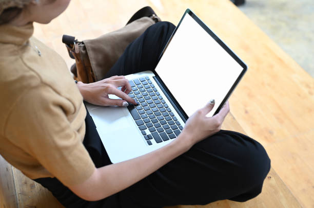 istock Cropped shot of young male freelancer working on her project with blank screen laptop while sitting on wooden floor. 1282775768