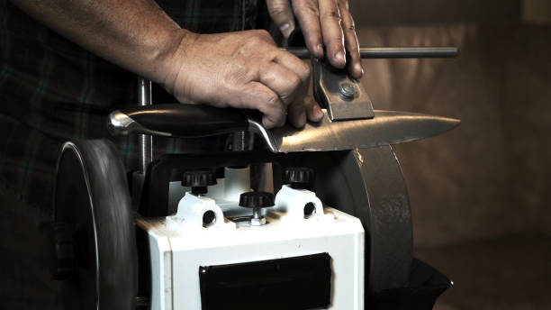 istock Man sharpens knives on a grinder. Close up hand 1282776093