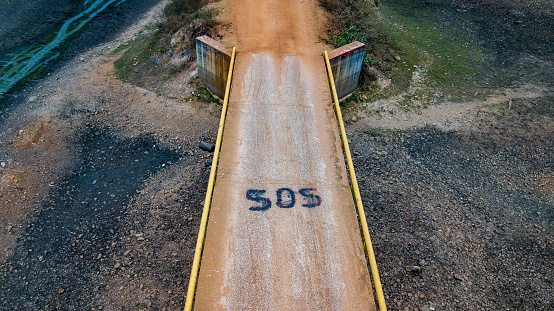 SOS message on a bridge over a dry riverbed
