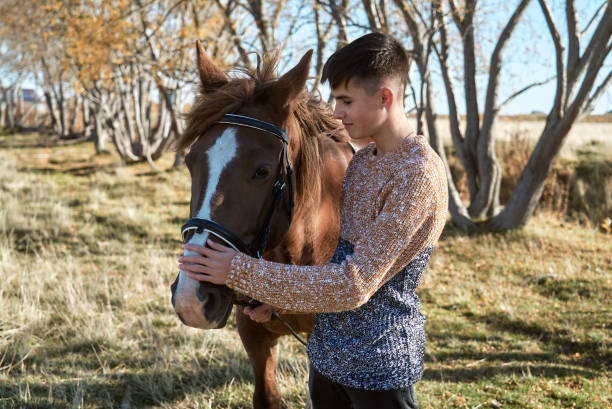 Boy teenager posing for a walk with a horse stock photo