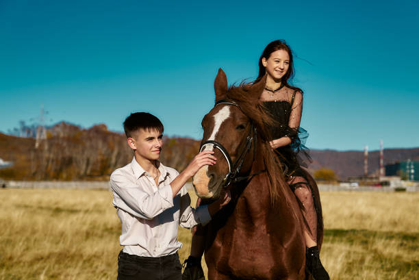 Boy leads a horse with a rider by the bridle stock photo