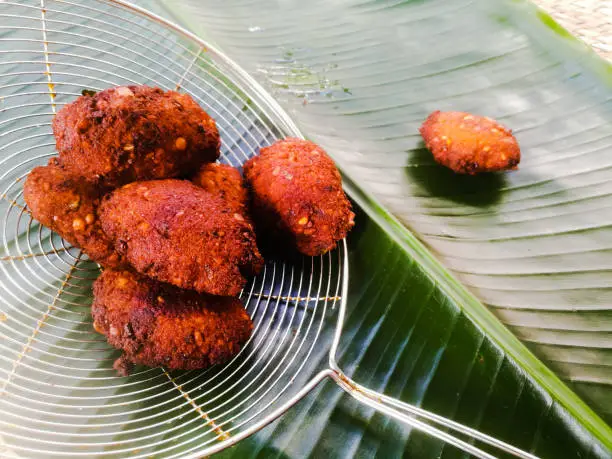 Photo of Fried parippu vada placed in a banana leaf in traditional fashion.