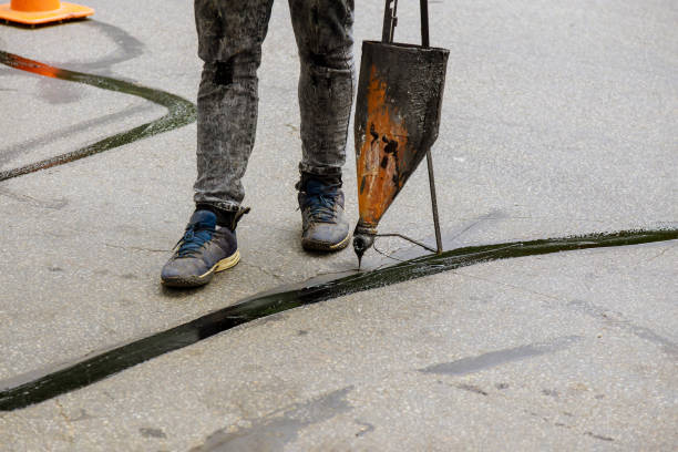 istock Sealing joint crack in asphalt road surface restoration work asphaltic joint 1282788649