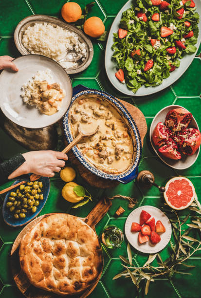 istock Female hands serving Turkish lamb in sauce over green table 1282793886