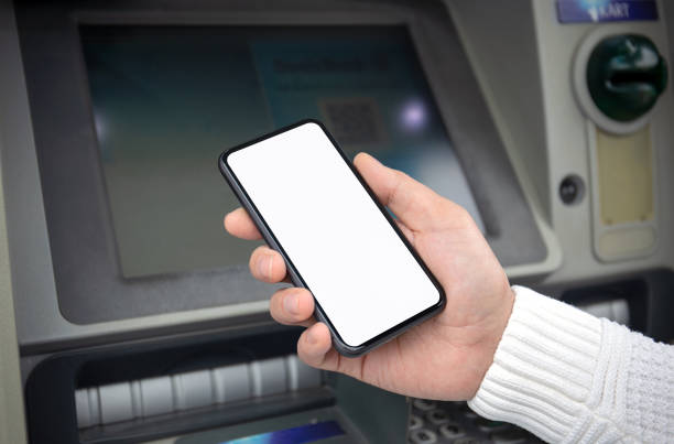 istock male hand holds phone with isolated screen at ATM 1282796471