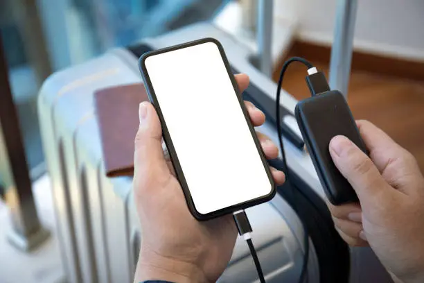 Photo of man hands holding phone with isolated screen and powerbank suitcase