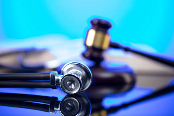 Medical law concept. Gavel, legal code and stethoscope on the glass table. Blue light. legislation photos stock pictures, royalty-free photos & images