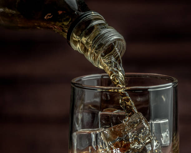 istock Whiskey pours from a bottle into a glass 1282801787