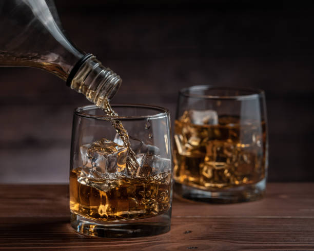 istock Whiskey pours from a bottle into a glass 1282802129