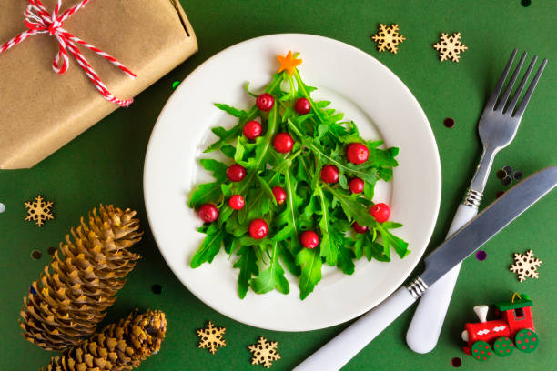The Christmas tree salad on white plate on table. Flat lay stock photo