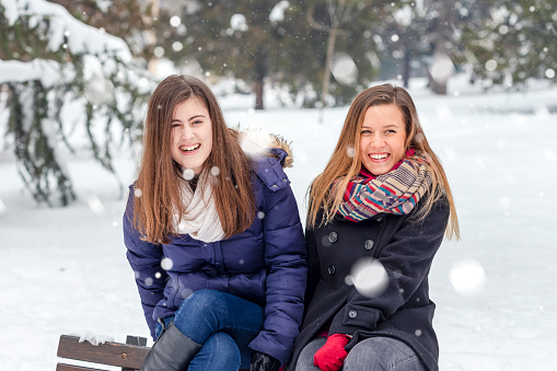 Young women enjoying in snow in public park