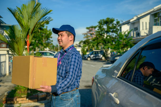 istock Asian man delivering cardboard box at doorstep 1282808455