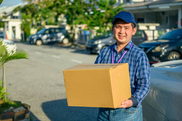 istock Asian man delivering cardboard box at doorstep 1282808459