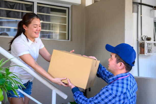 istock Goods delivery man handing over a cardboard box 1282809444
