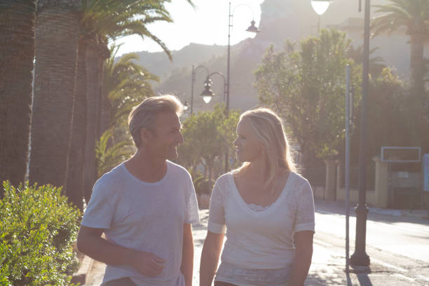 istock Couple walk down coastal walkway at sunrise 1282809584